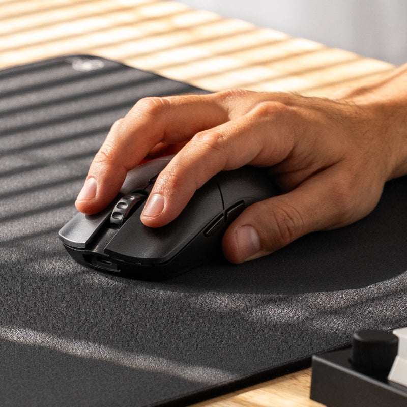 A close-up of a hand using a Model O 2 PRO Series Wireless Mouse on a black mousepad, with a GMMK PRO 75% partially visible in the foreground.