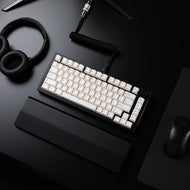 Top view of a black desk setup with a GMMK PRO 75%, headphones, and a Model O 2 PRO