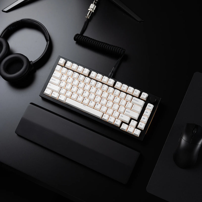 Top view of a black desk setup with a GMMK PRO 75%, headphones, and a Model O 2 PRO