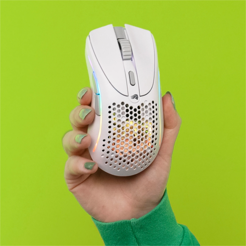 Hand holding up the Model D 2 Wireless in White on a green background