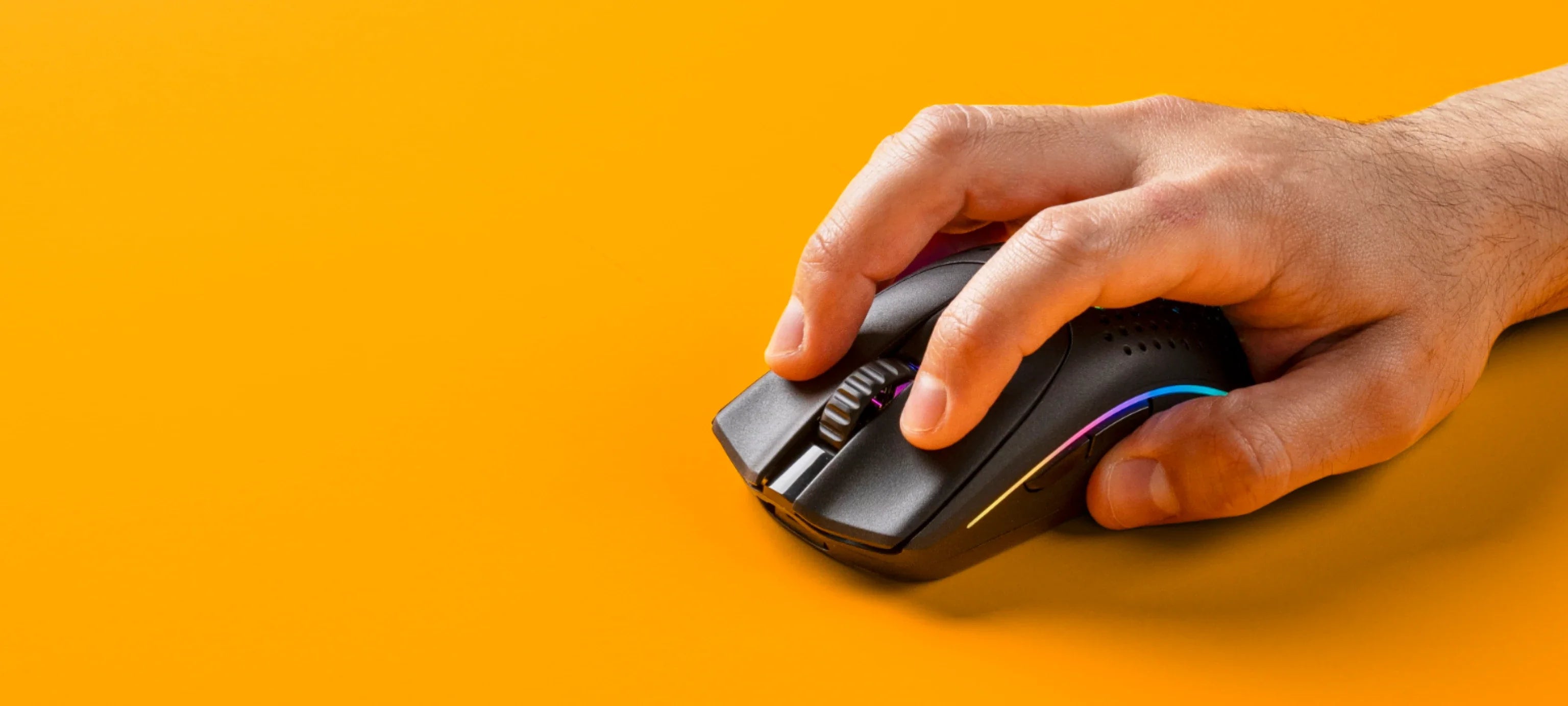 Hand holding a Model O 2 Wireless in Black on an orange background