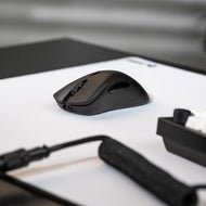 A desk setup focusing on the left side of the Model D 2 PRO with a white mousepad and GMMK PRO