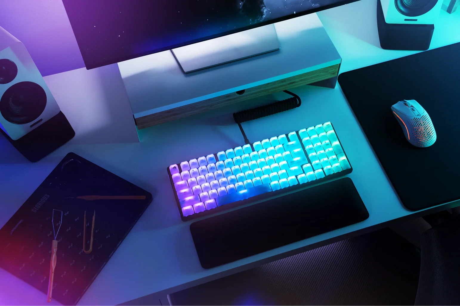 Polychroma RGB keycaps shown in a desk setup with blue and purple lighting